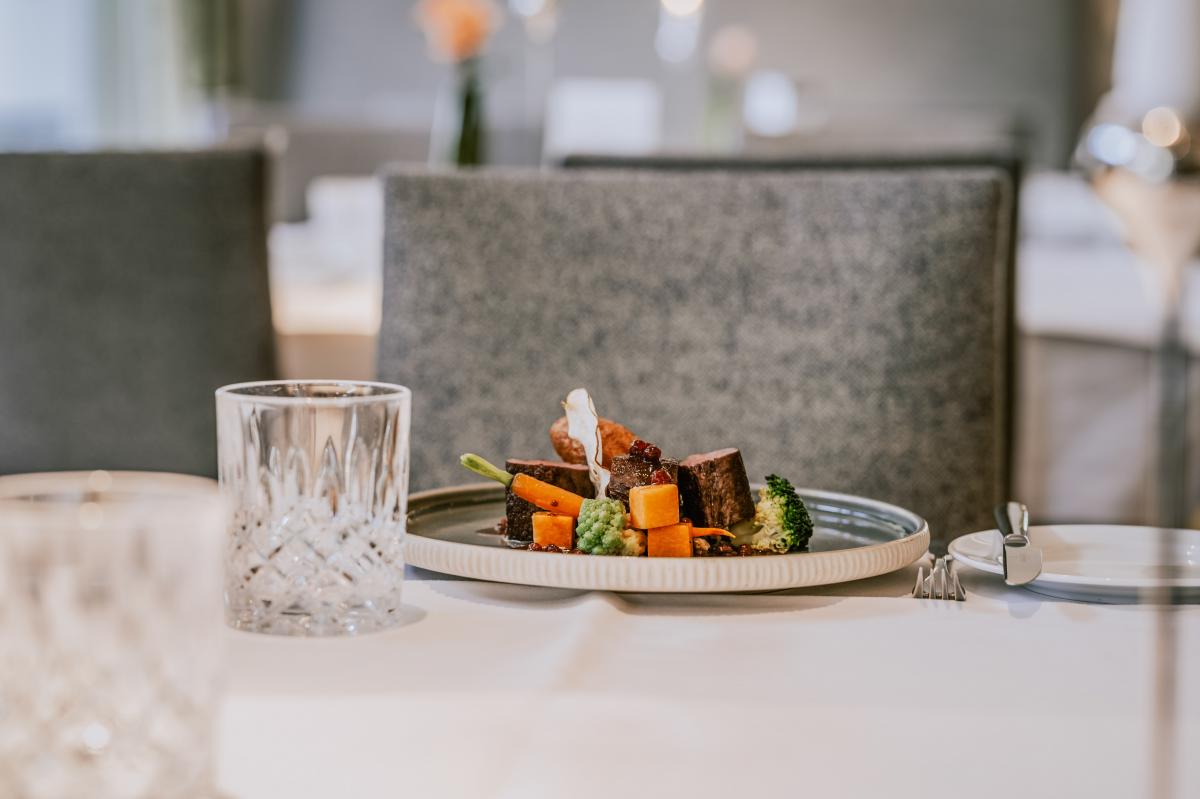 Verschwommener Vordergrund mit Hauptgang auf Teller im Hintergrund